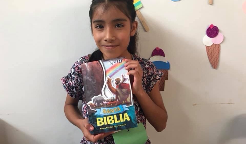 Girl Receiving a Book Gift from CRI
